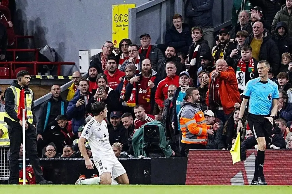 Maguire on his knees in front of the Liverpool fans after his late winner, Anfield, 19 Oct 2025